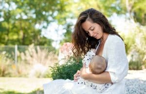 Une femme allaitant son bébé en extérieur