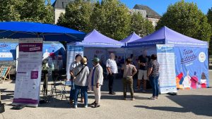 Le stand de la caravane "Tous Aidants", qui est bleu. Il y a du monde devant.