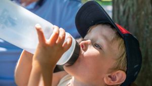 enfant buvant avec une gourde