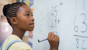 Jeune fille faisant des mathématiques au tableau