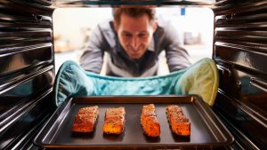 un homme sort du poisson du four