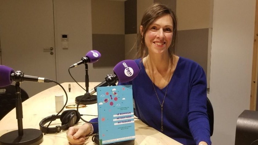 Lyne Derose pose avec le livre qu'elle a coécrit