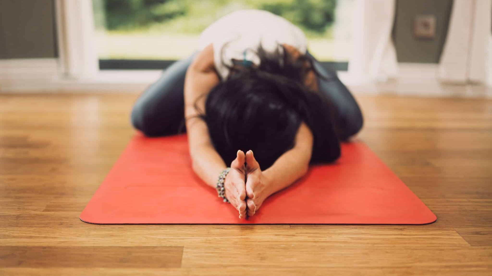 Une femme dans une position de yoga à la maison