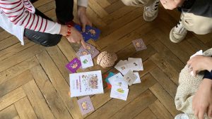 Les cartes de jeu l'attrape temps sont étalés au sol près d'un cerveau en plastique