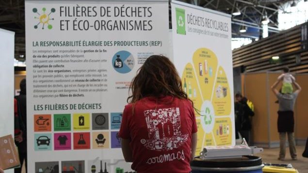 une personne regarde un panneau intitulé "les filières de déchets et éco_organismes"