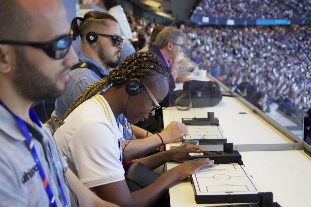 Femme aveugle qui suit un match de football avec la tablette tactile, au Stade de France