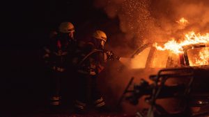 Deux pompiers éteignent un feu